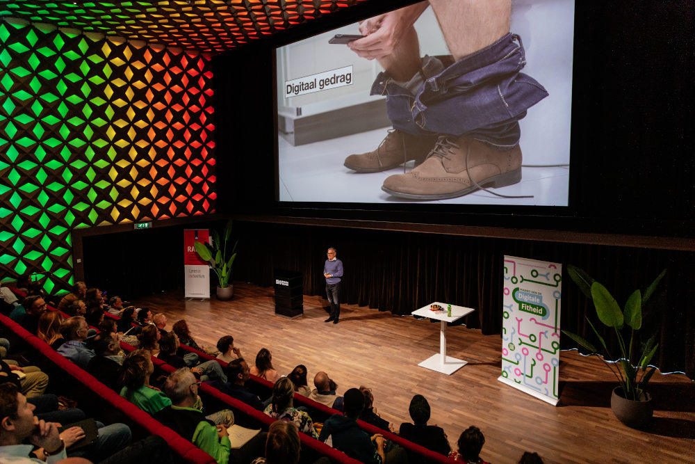 Rijn Vogelaar vertelt op het podium over zijn onderzoek.